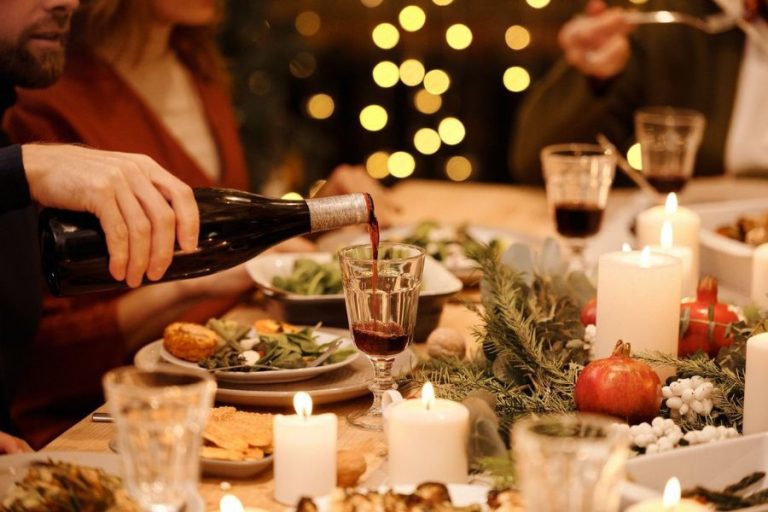 Cena con abundante comida y vino, entorno que puede favorecer atracones.