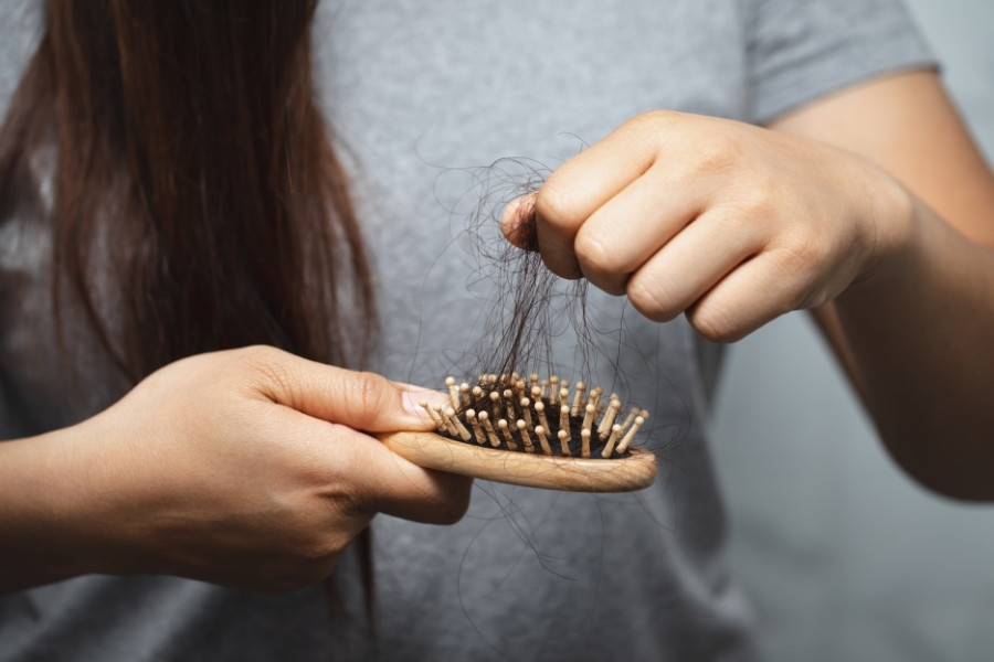 Mujer observando la caída del cabello en un cepillo