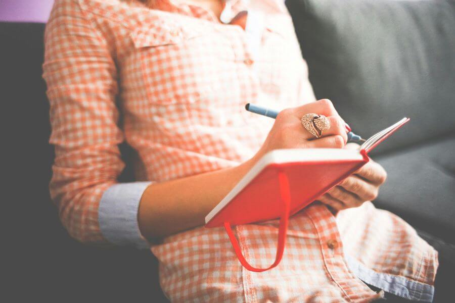 Persona escribiendo en un diario de sueños, una técnica clave para mejorar la memoria onírica y recordar los sueños con mayor claridad.