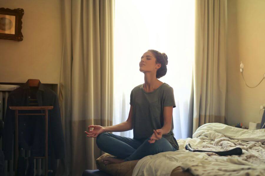 Persona meditando antes de dormir para fortalecer el recuerdo de los sueños y conectar el mundo onírico con la vida consciente.