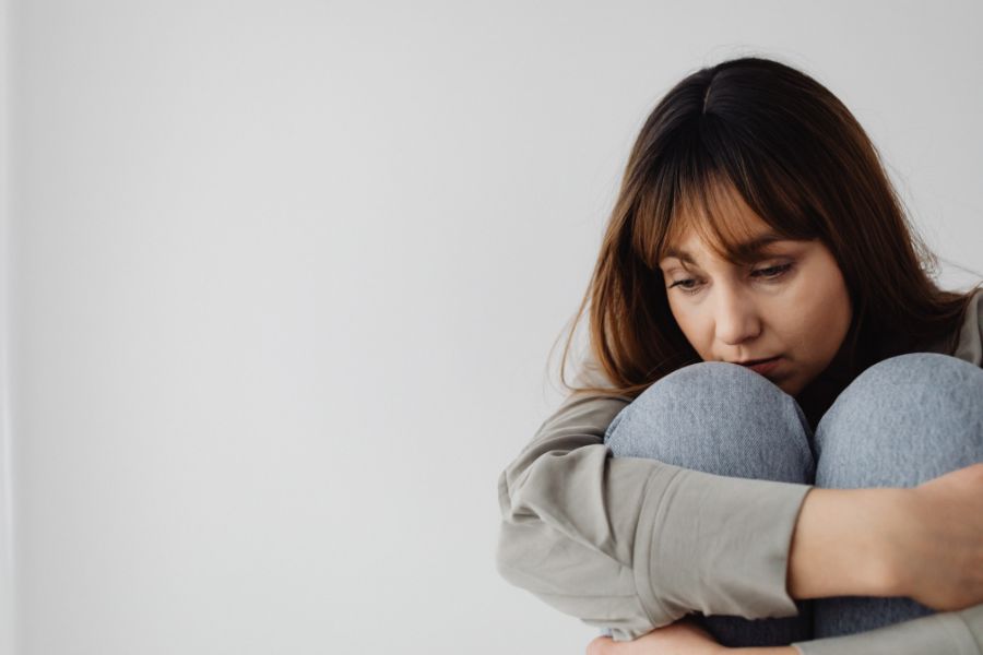 Mujer cabizbaja simbolizando el desgaste emocional de vivir con una persona narcisista.

