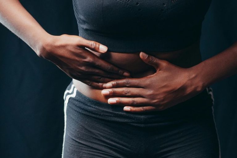 Persona con dolor abdominal sosteniendo su vientre, síntoma frecuente del SIBO o sobrecrecimiento bacteriano intestinal.