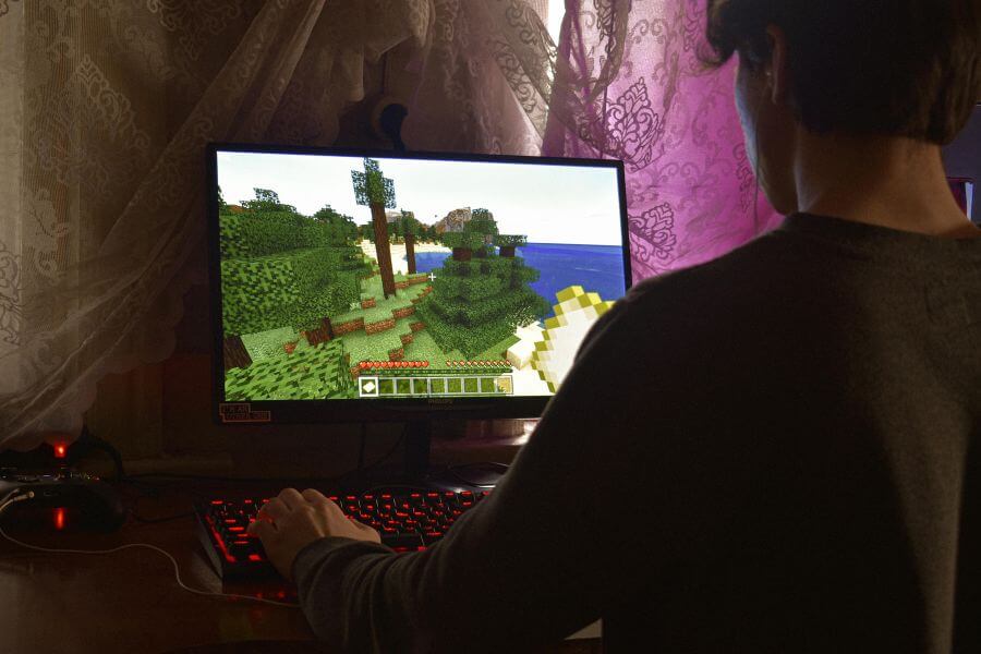 Niño jugando Roblox en el ordenador con gráficos del juego en pantalla.