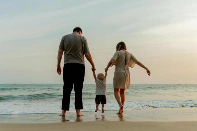 Familia disfrutando en la playa al atardecer como símbolo de unión y proyecto y sentido en la vida.
