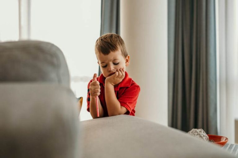 Niño pensativo mostrando signos de cansancio, ejemplo de síntomas en la infancia y adolescencia.