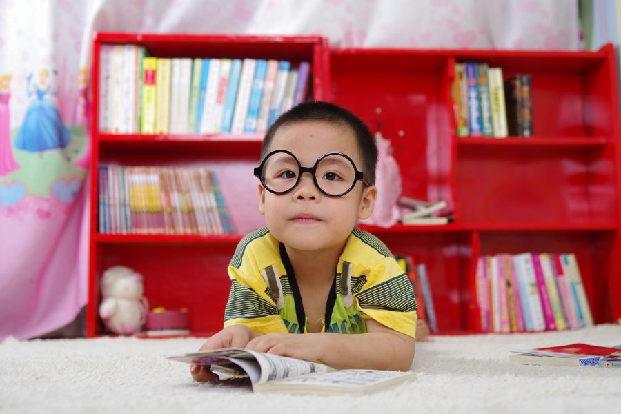 Niño concentrado leyendo en un entorno estructurado, reflejo de la autoexigencia del niño perfecto