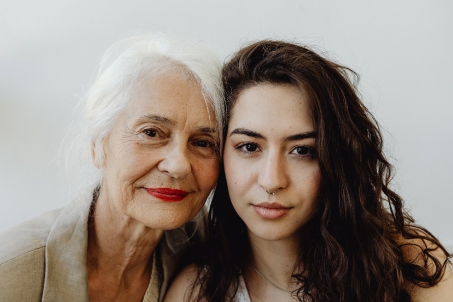 Retrato de primer plano de dos mujeres de distintas generaciones, una mayor con cabello blanco y una joven, representando el legado y la transmisión de modelos de pareja entre padres e hijos.
