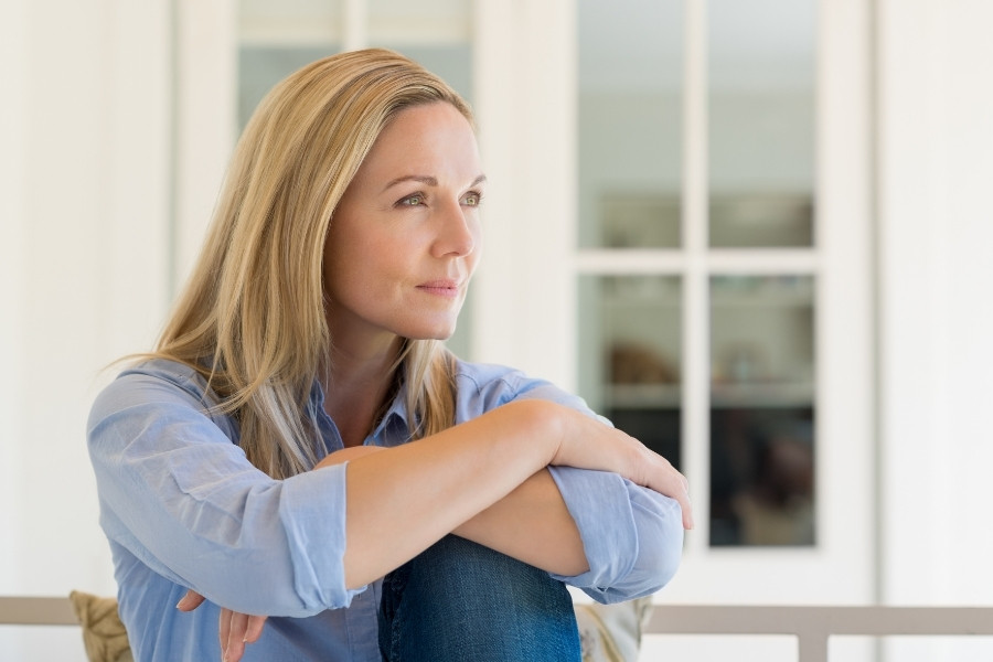Mujer con expresión reflexiva representando la relación entre mamas fibroquísticas y biodescodificación según los conflictos emocionales de protección.