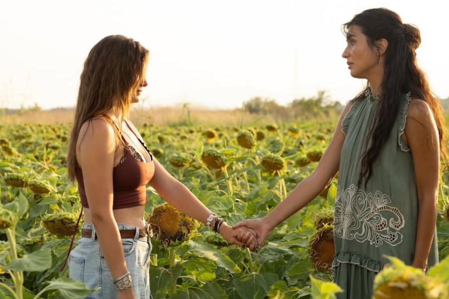 Ada y su hermana Deniz cogiéndose de la mano en un campo de girasoles en una escena de Mi otra yo temporada 3