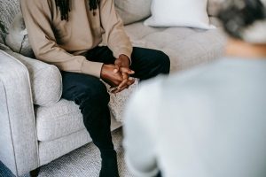 Terapeuta escuchando y acompañando a una persona durante una conversación.